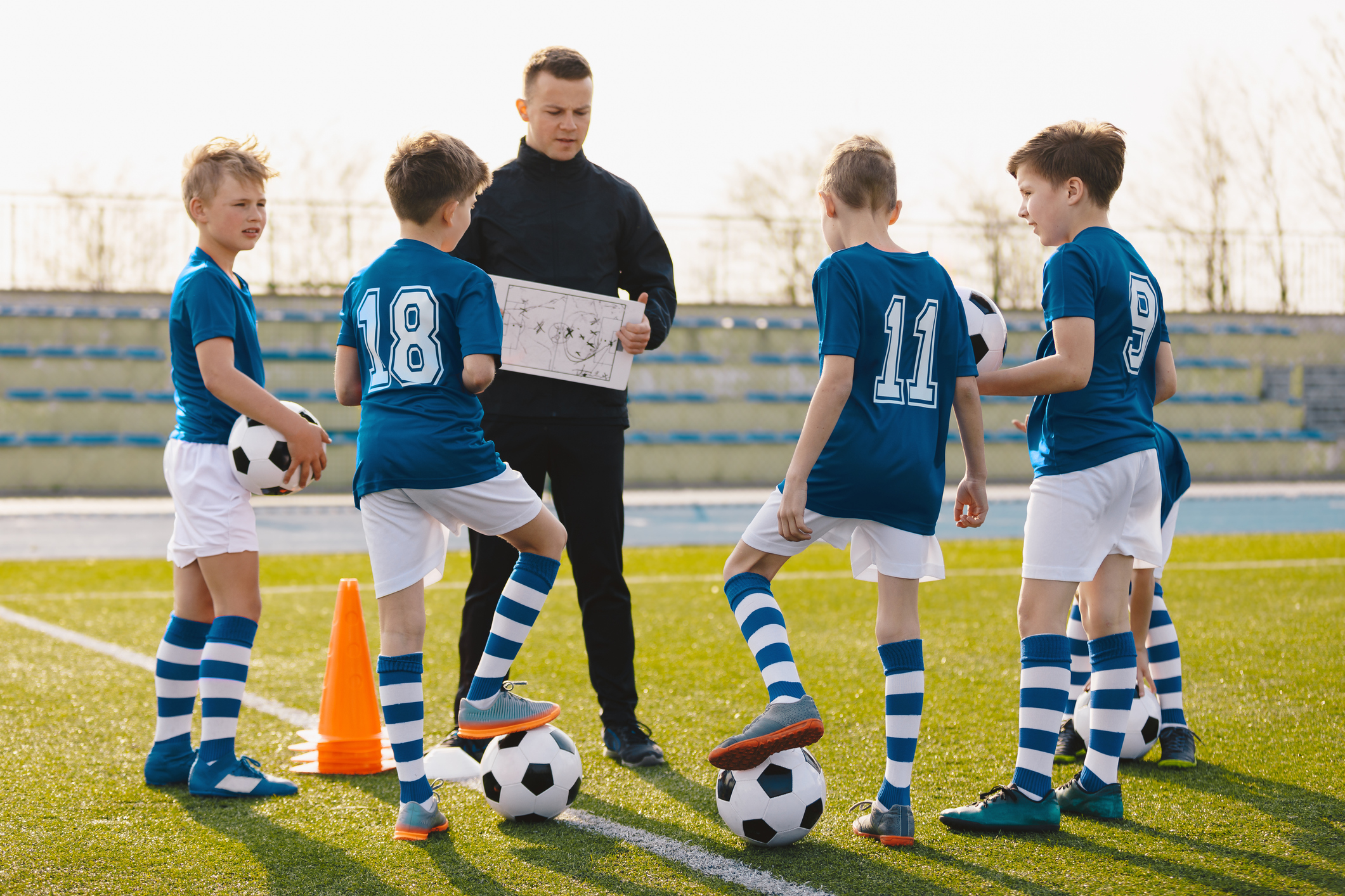 Soccer coach instructs young players.