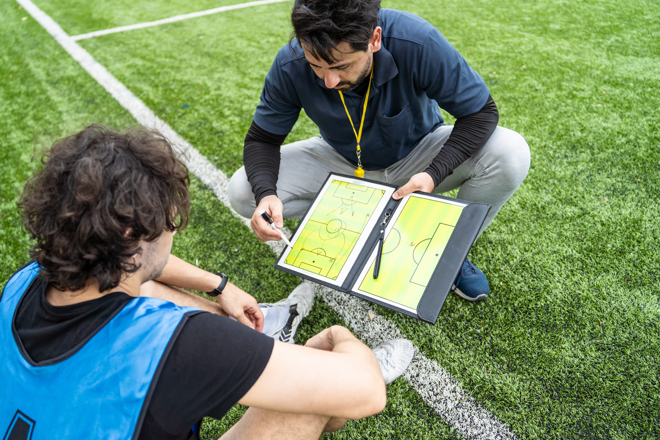 Coach explaining soccer tactics to player